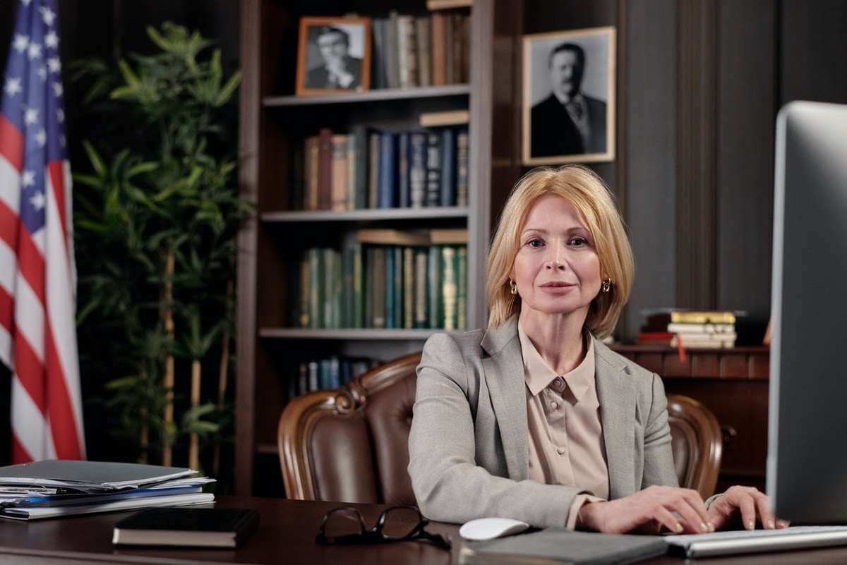 Professional woman sitting behind a desk in a law office.