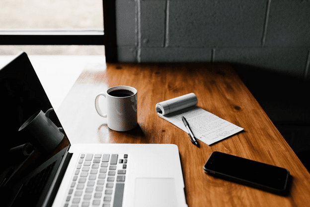 Coffee phone laptop and notepad on a desk - how many grad schools should I apply to?